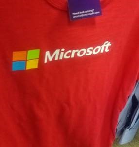 Photograph of a red shirt with a Microsoft label and logo.