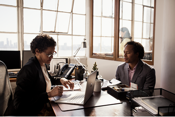 Image of a generic business people at a desk in an office setting.